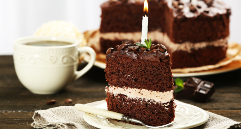 Part de gâteau au chocolat recouvert de ganache avec une bougie