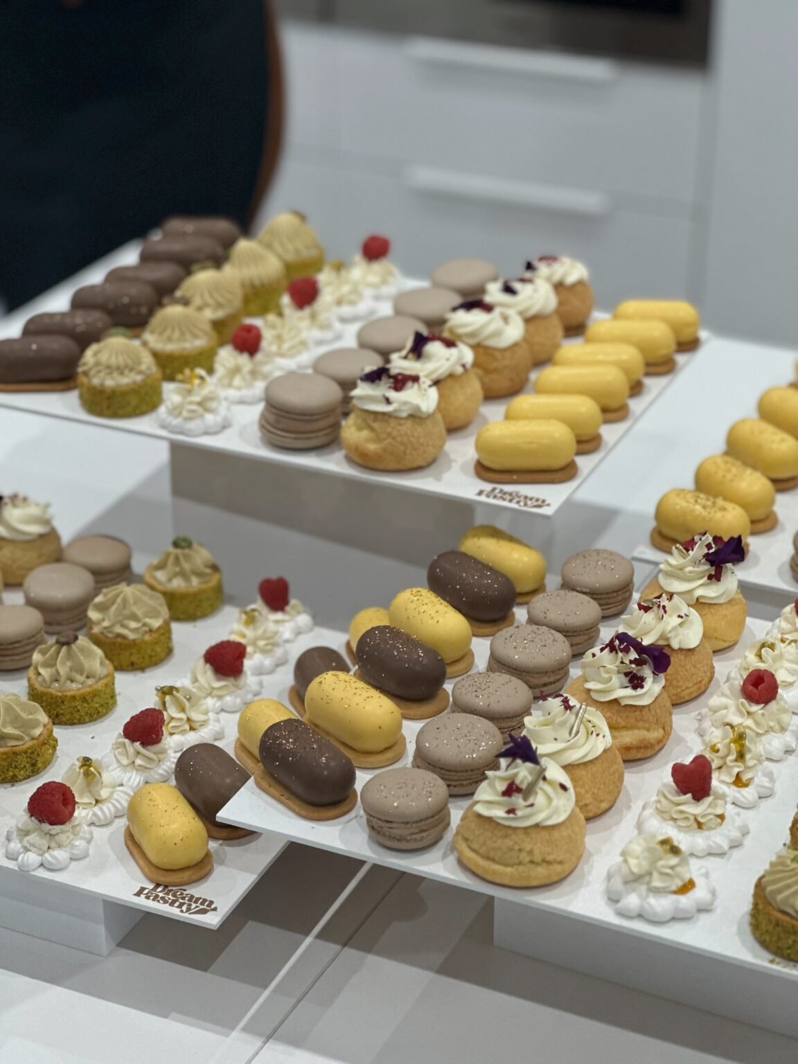 Vitrine de mignardises : éclairs, tartelettes, choux et macarons