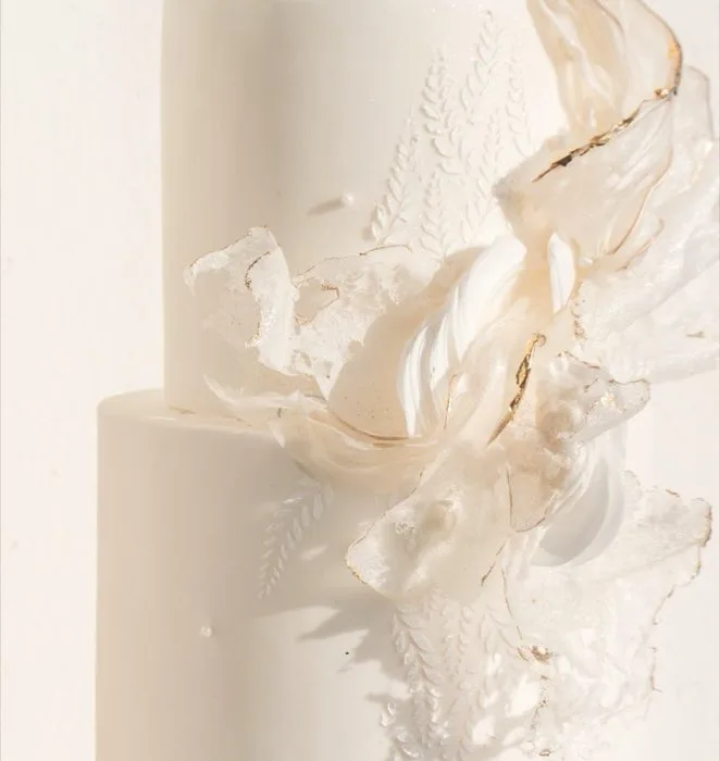 Wedding cake blanc aux fleurs délicates, photographié pour le catalogue